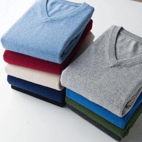Stack of folded classic v-neck jumpers in blue, grey, navy, red and green