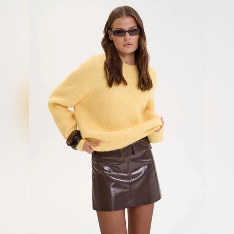 Woman wearing a soft yellow relaxed crew neck jumper