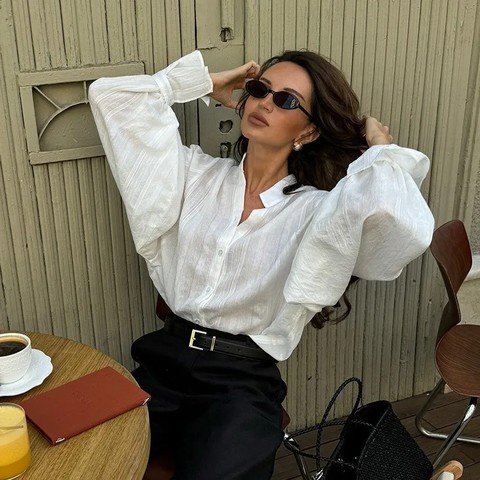 Woman wearing an oversized white shirt with black trousers